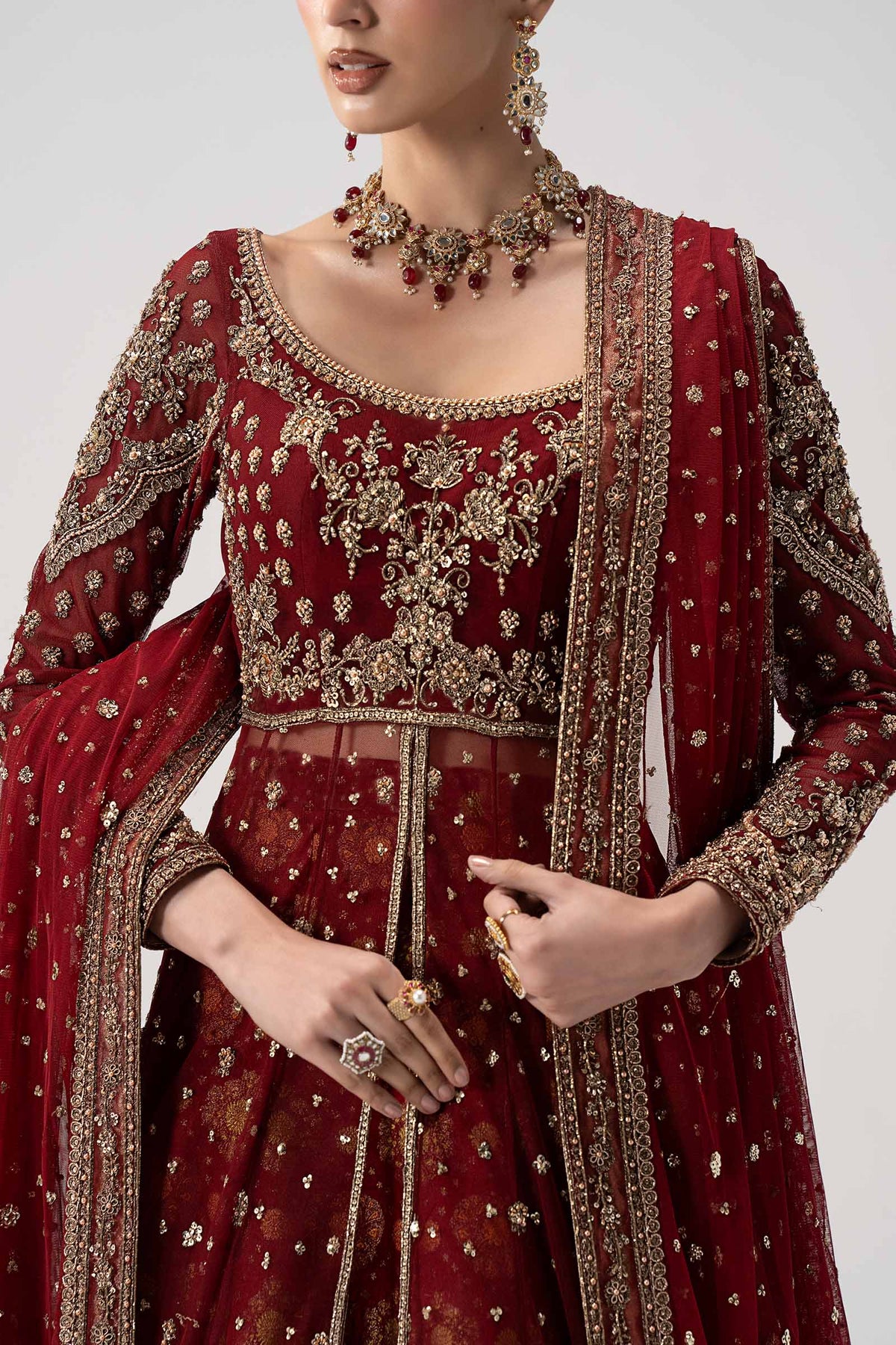 Close-up of Maria B Bazif antique gold Kora Dabka handwork, floral embroidery and embellishments on deep red bridal bodice