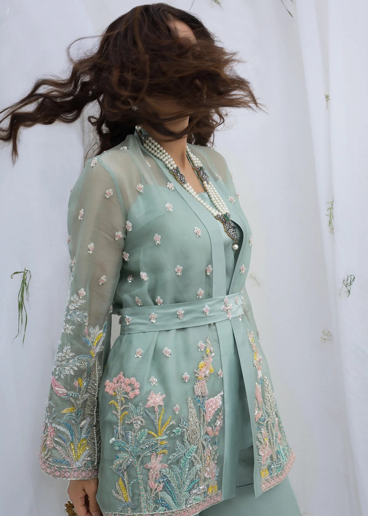Back view of mint green embroidered organza Pakistani designer dress showcasing detailed craftsmanship, luxury formal wear for wedding guests and festive events.