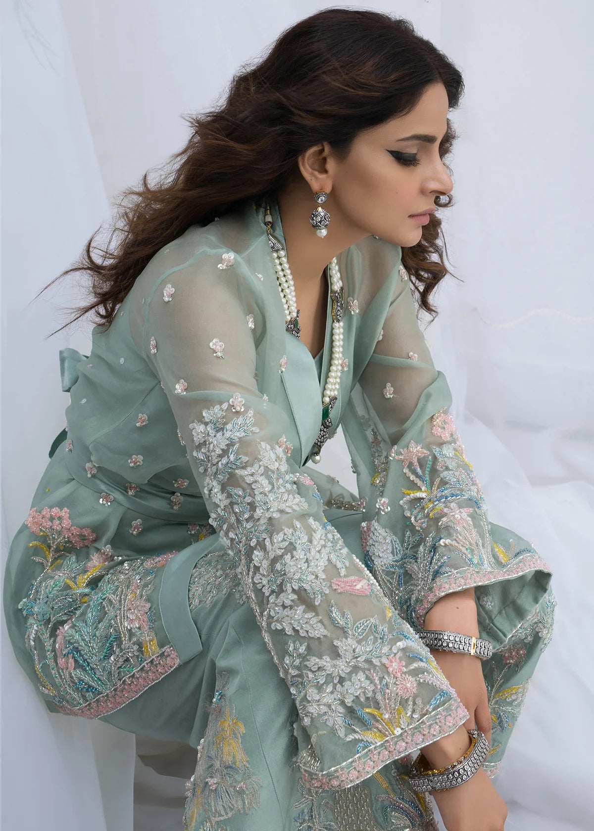 Side view of luxury Pakistani designer organza suit in mint green featuring intricate floral embroidery, premium party wear dress for women
