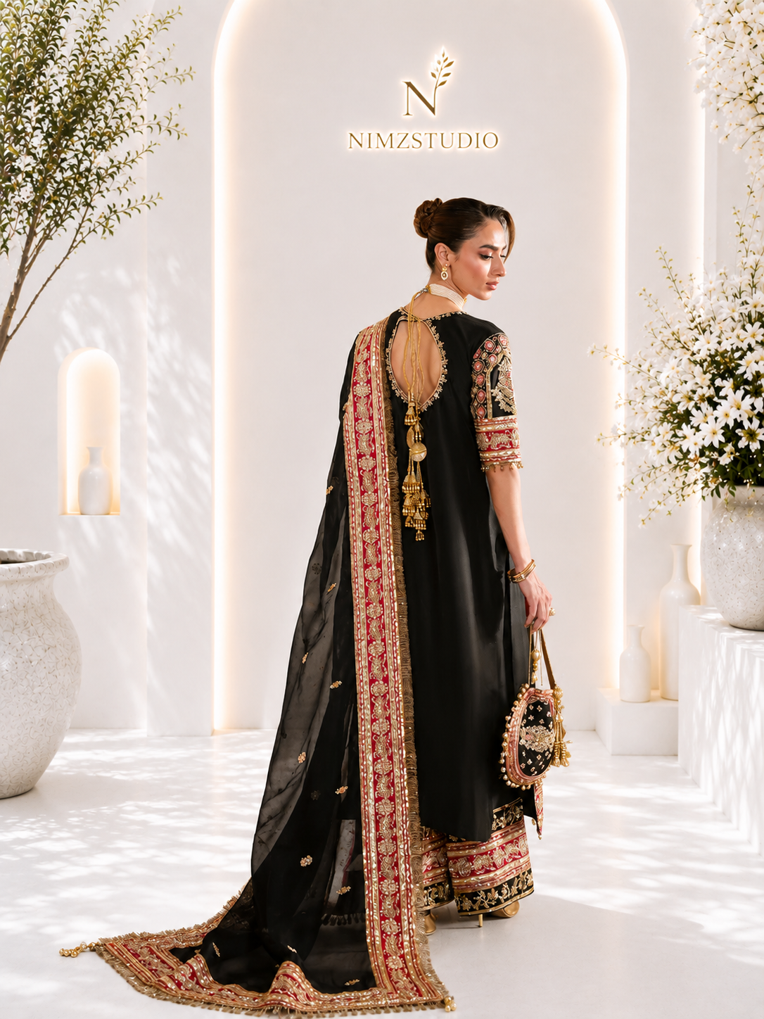 Back view of black Pakistani designer partywear dress with embroidered dupatta and luxury detailing b
