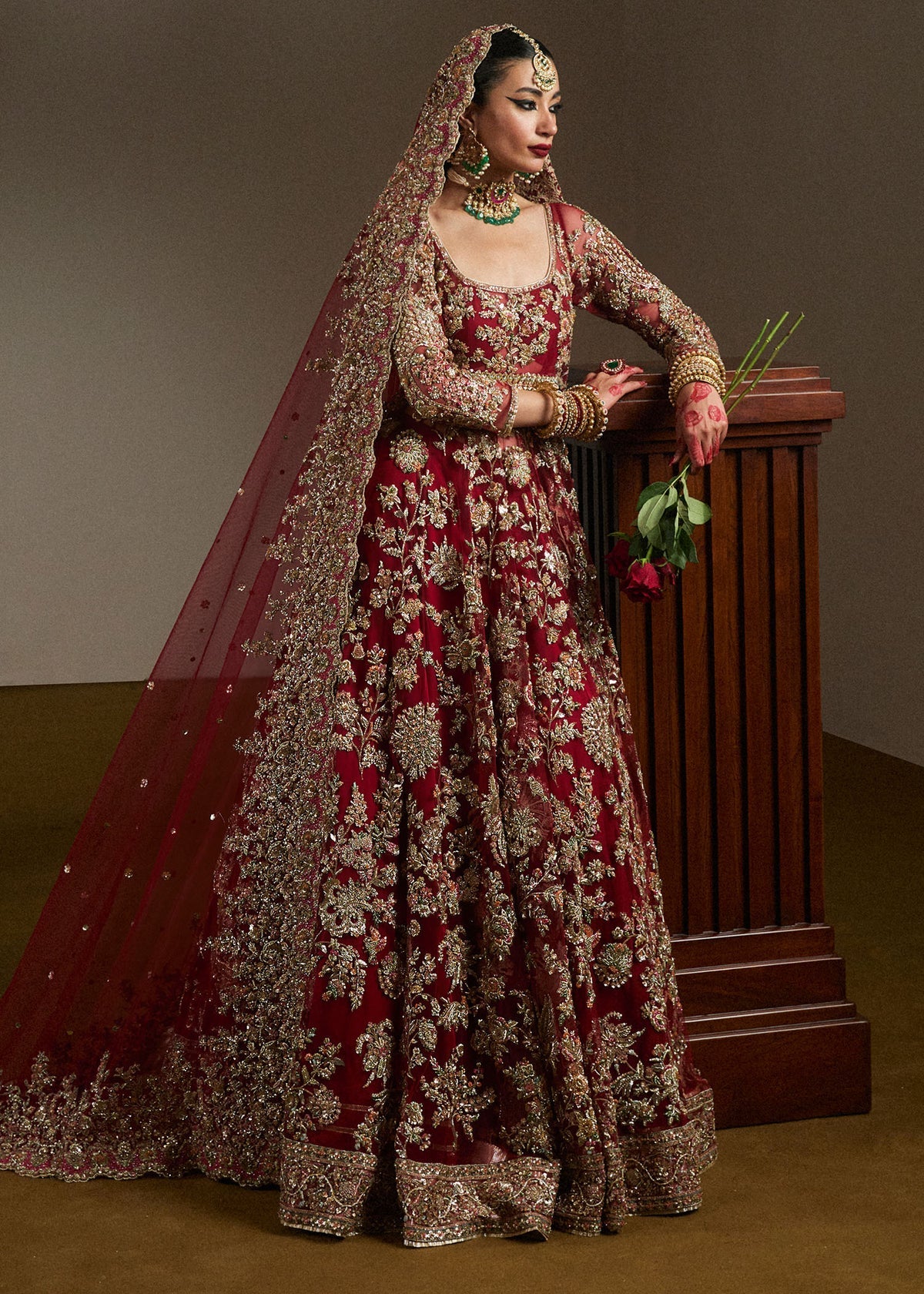 Side view of Hussain Rehar inspired Pakistani bridal maxi in deep maroon with intricate hand embroidery, premium bridal dupatta, luxury wedding outfit, and elegant couture detailing.